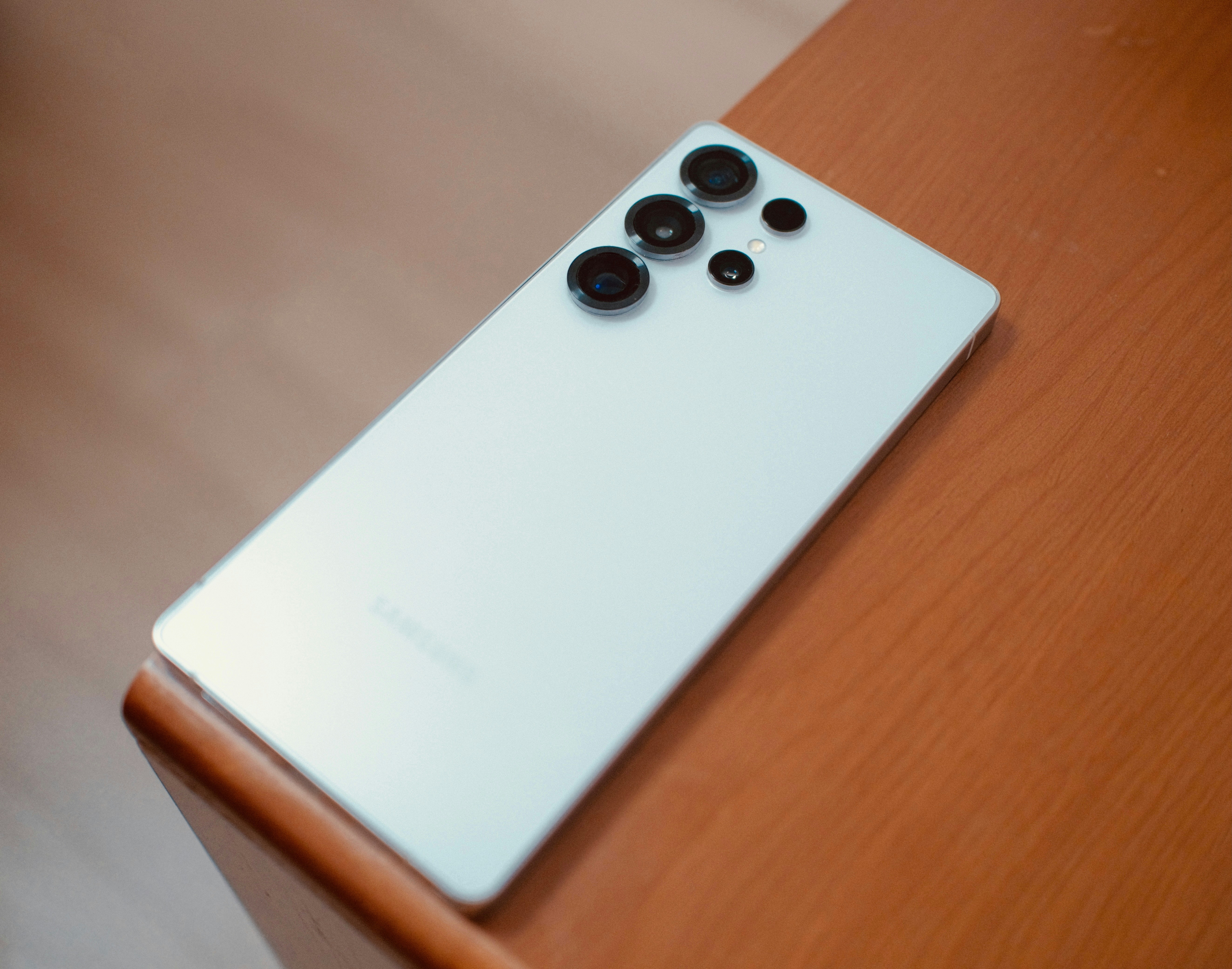 Smartphone mit mehreren Kameraobjektiven auf Holzoberfläche
