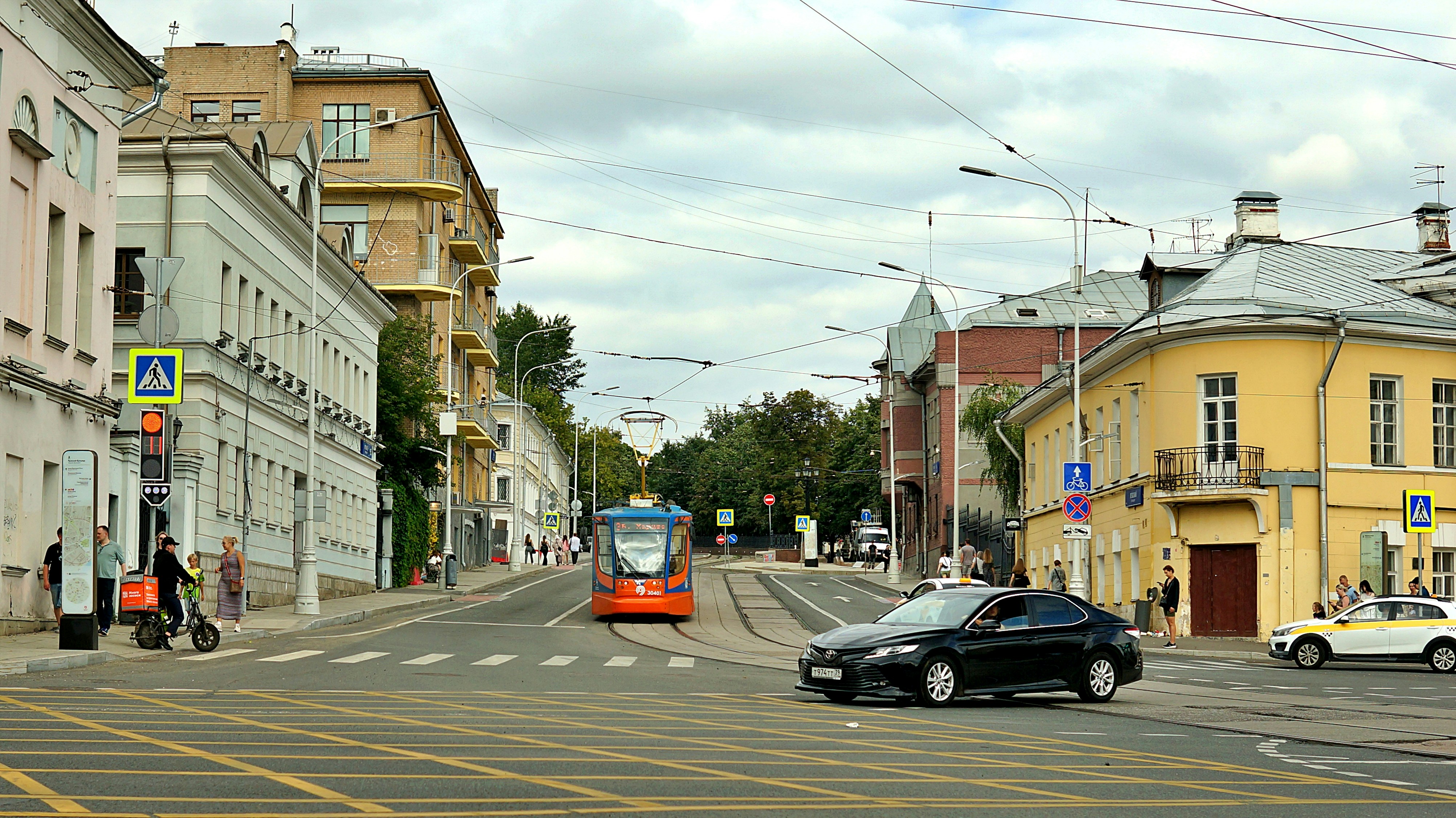 Compact affordable car driving on a city street at sunset