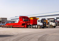 Several heavy-duty trucks parked outside a building.