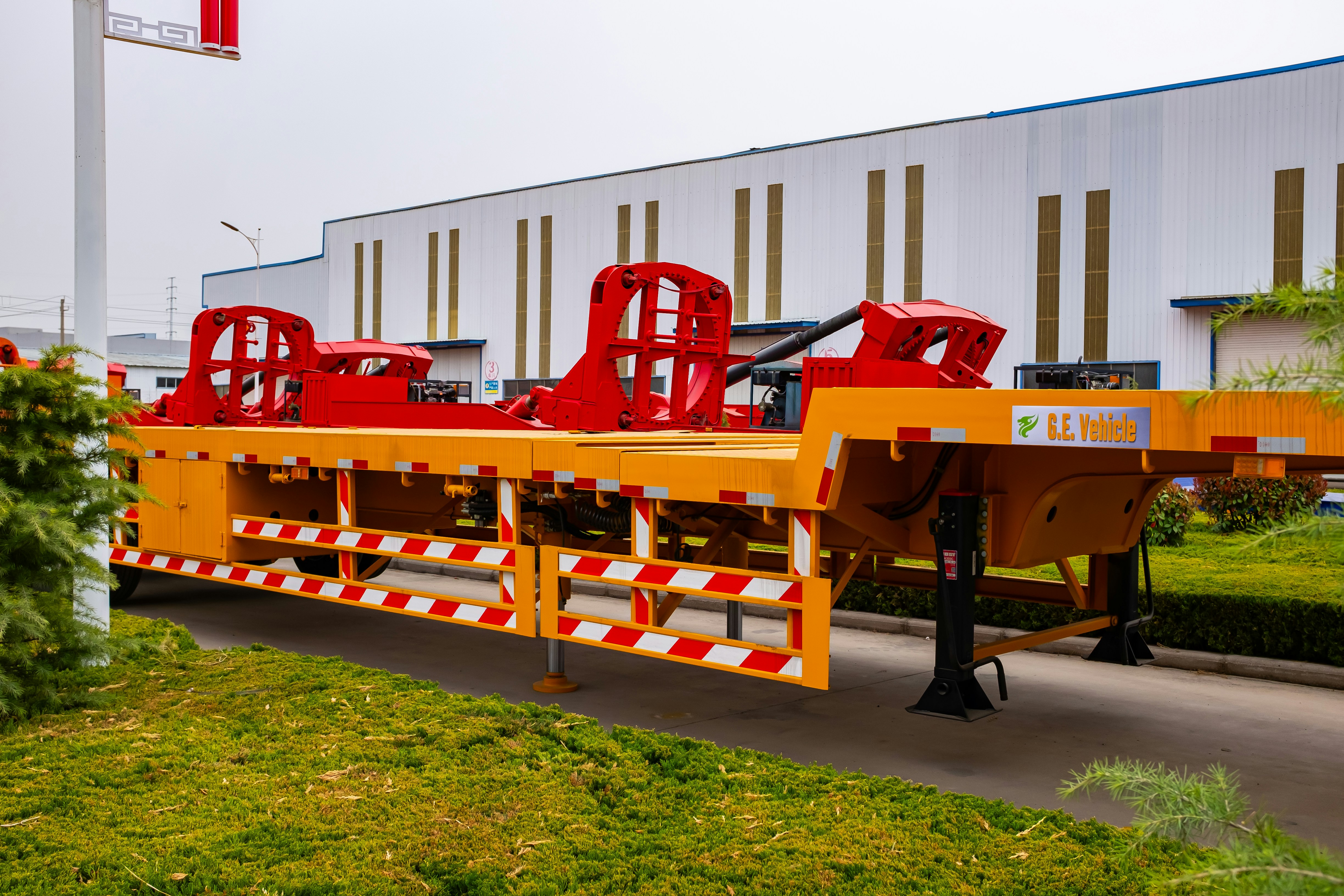 Yellow flatbed trailer with red metal structures