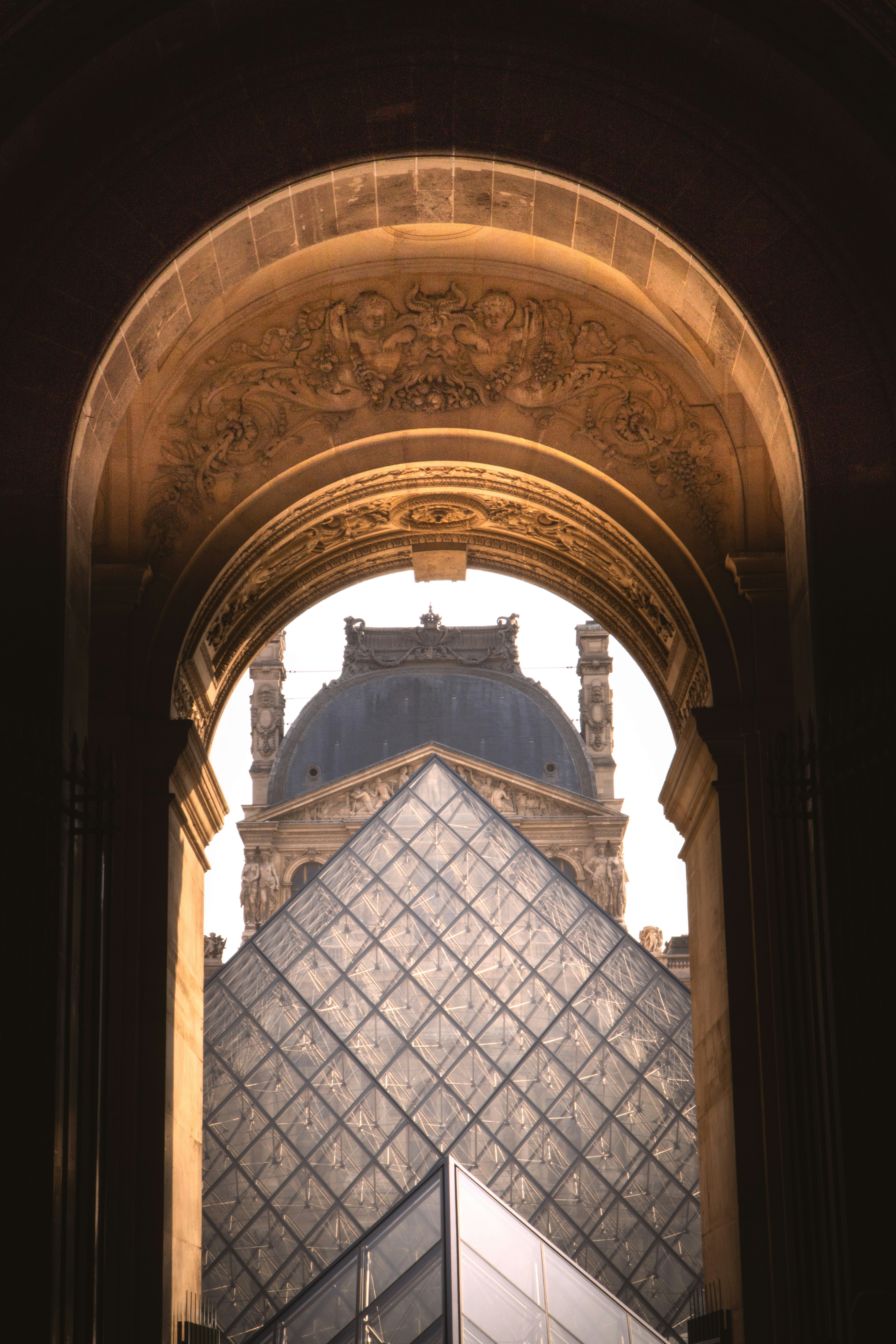 La pyramide du Louvre et le bâtiment du musée vus à travers l’arcade