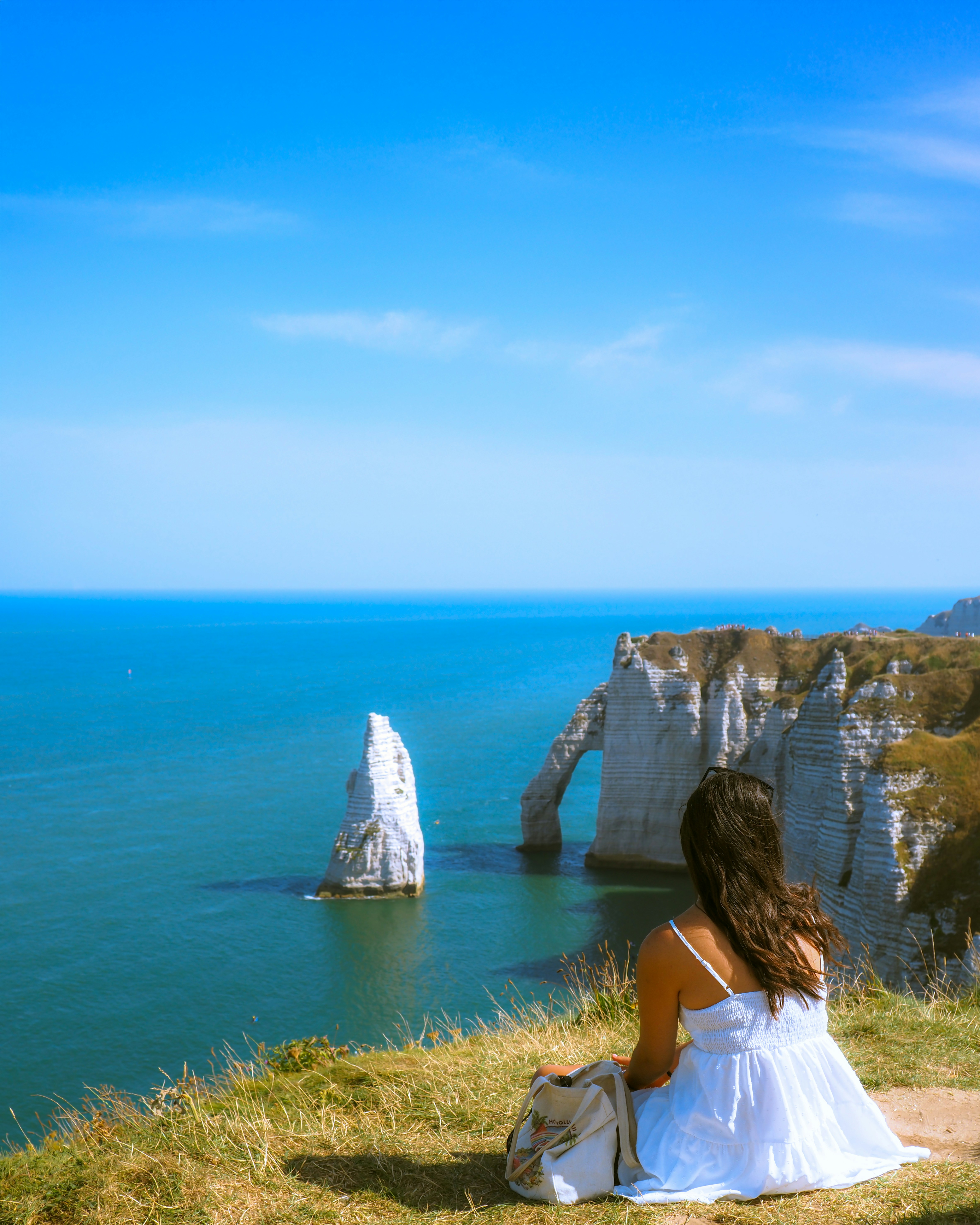 Femme en robe blanche surplombe les falaises de l’océan