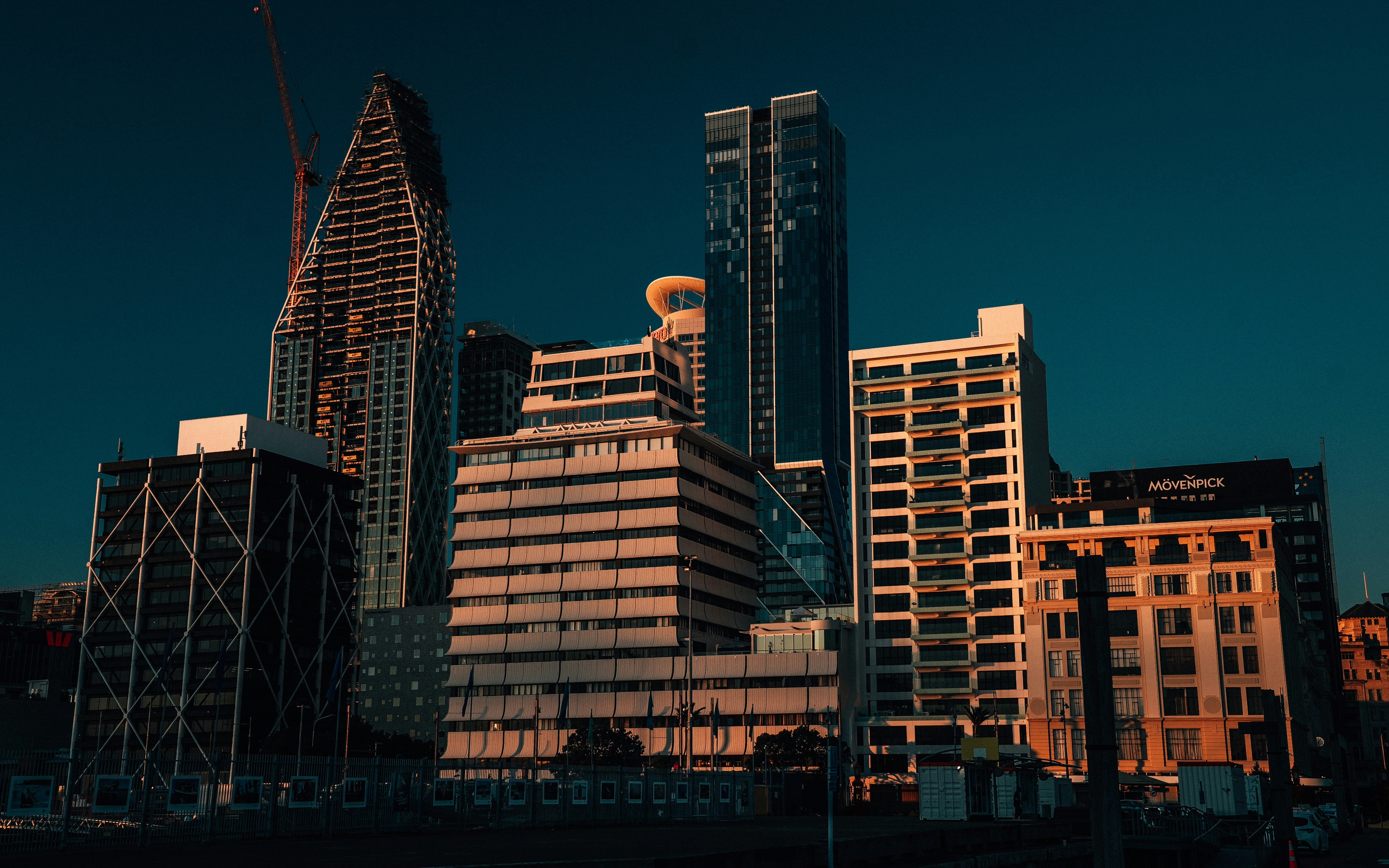 Modern skyscrapers illuminated by golden hour sunlight.