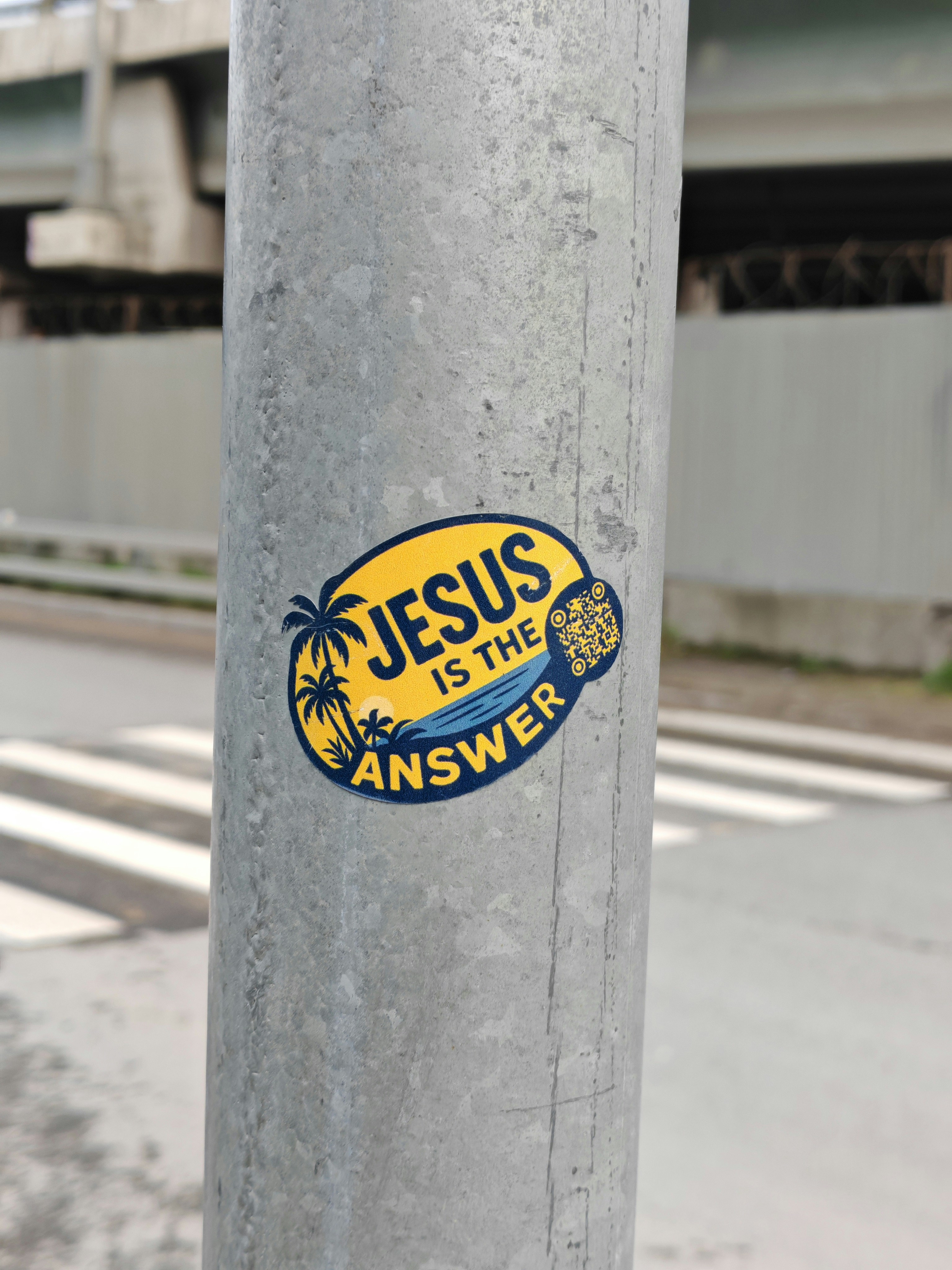 Sticker on pole reads "jesus is the answer".