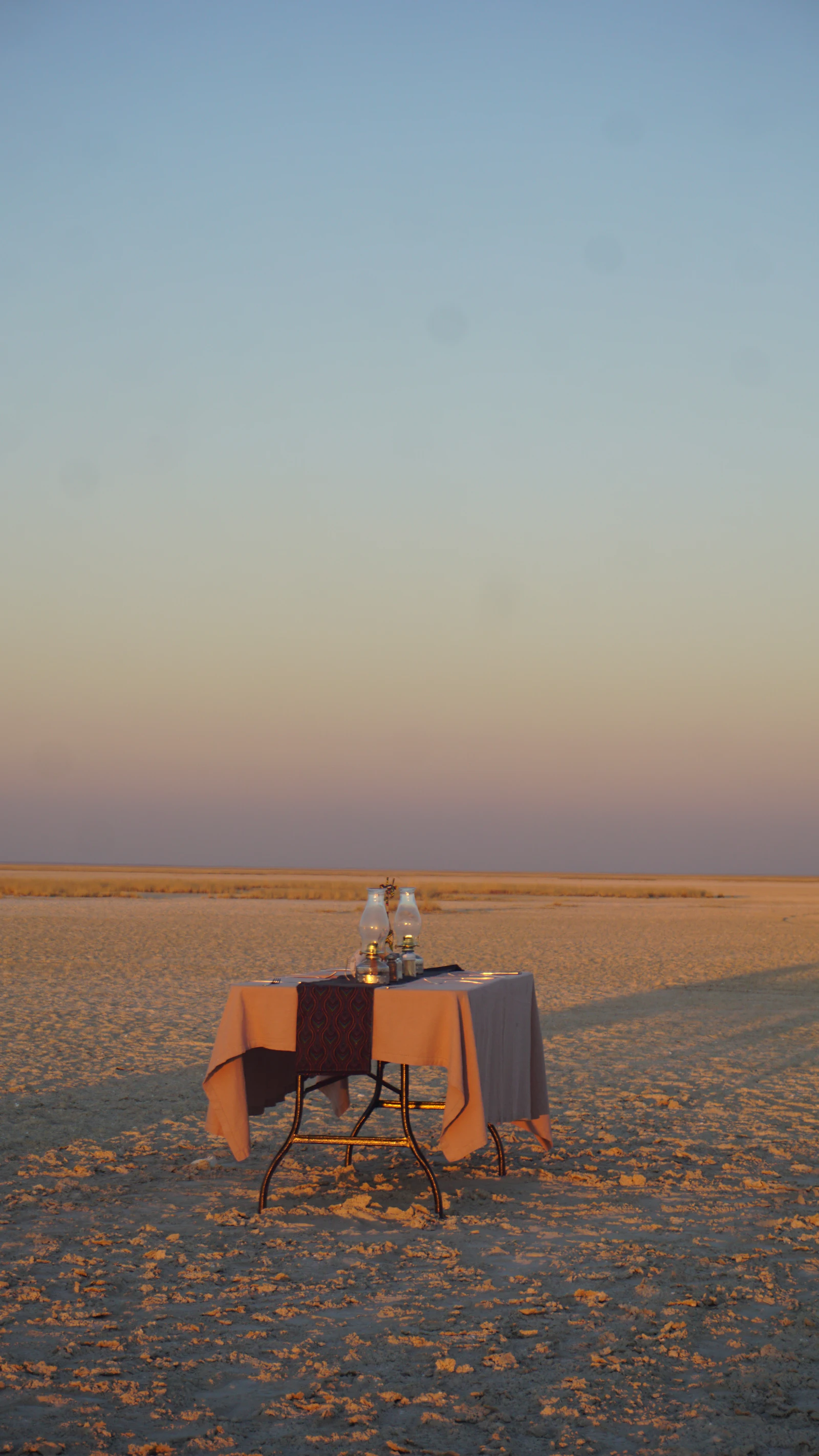Stock image: a dinner table with two paraffin lanterns standing alone on a pan at dusk