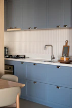 Modern kitchen with blue cabinets and stainless steel appliances.