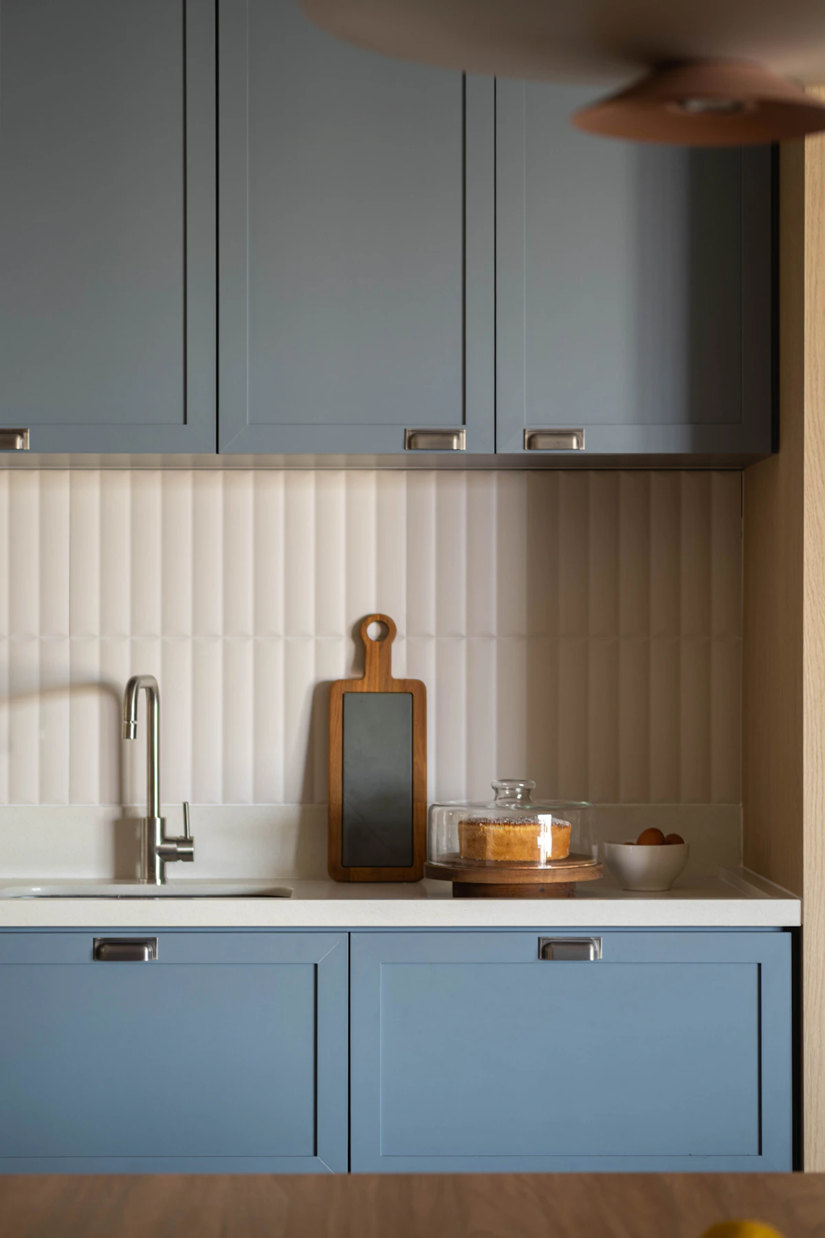 Cocina con gabinetes azul marino y detalles modernos — tendencia de color 2026