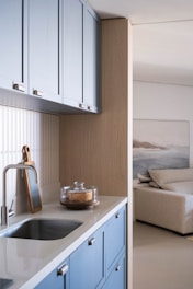 Modern kitchen with blue cabinets and a sink.
