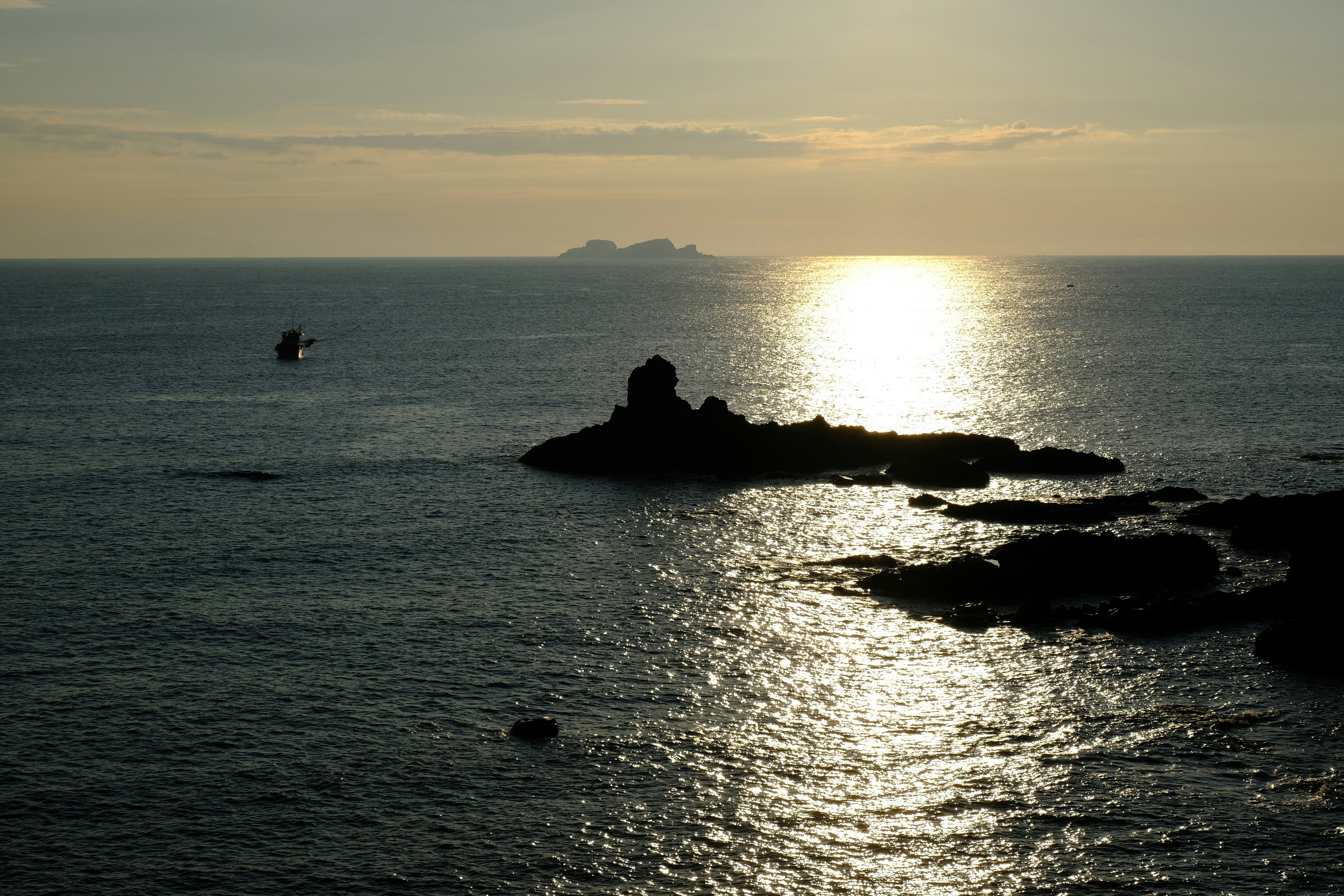 Sunset over the ocean with rocky islands.