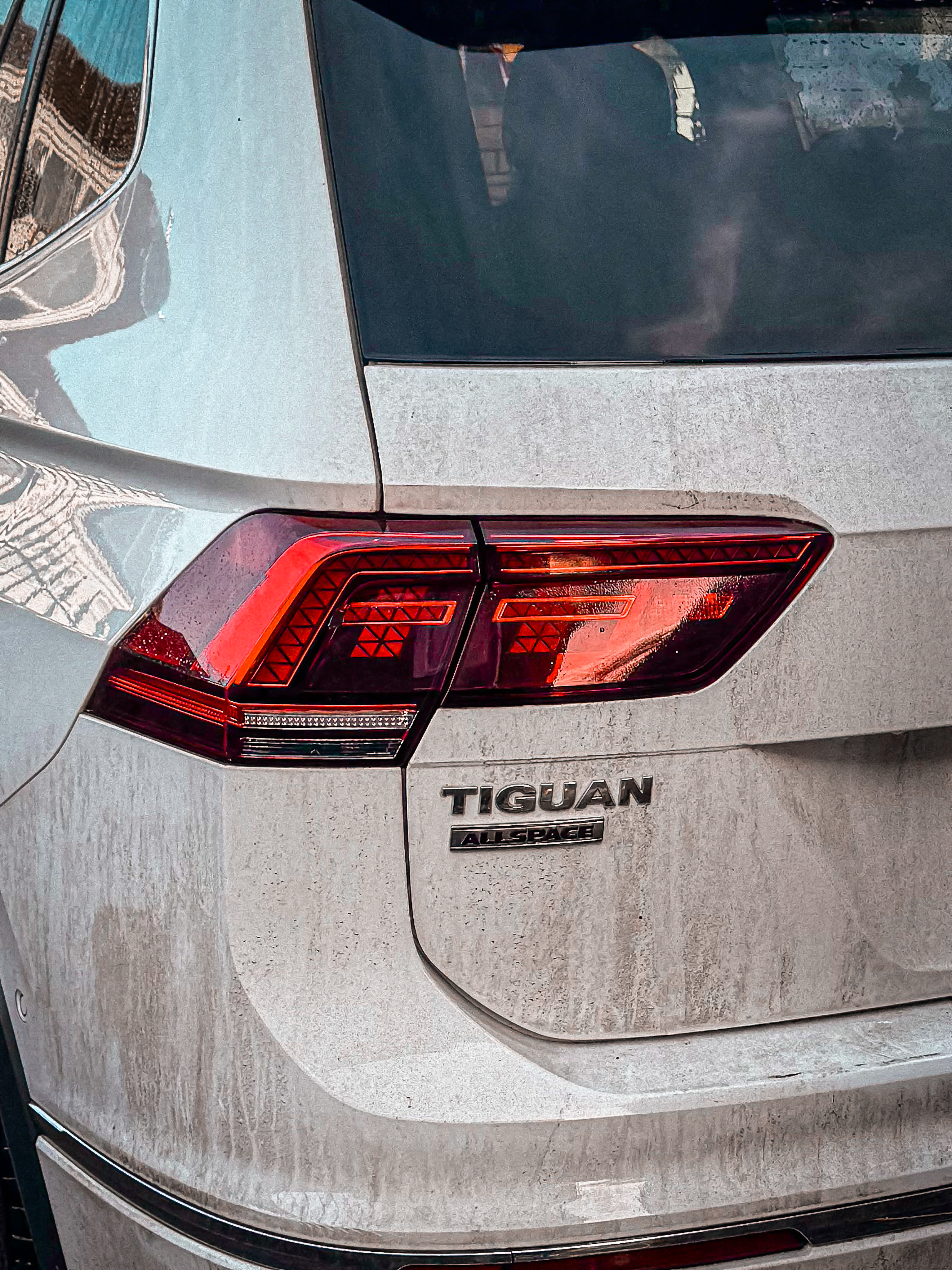 Close-up of a dirty white volkswagen tiguan taillight.