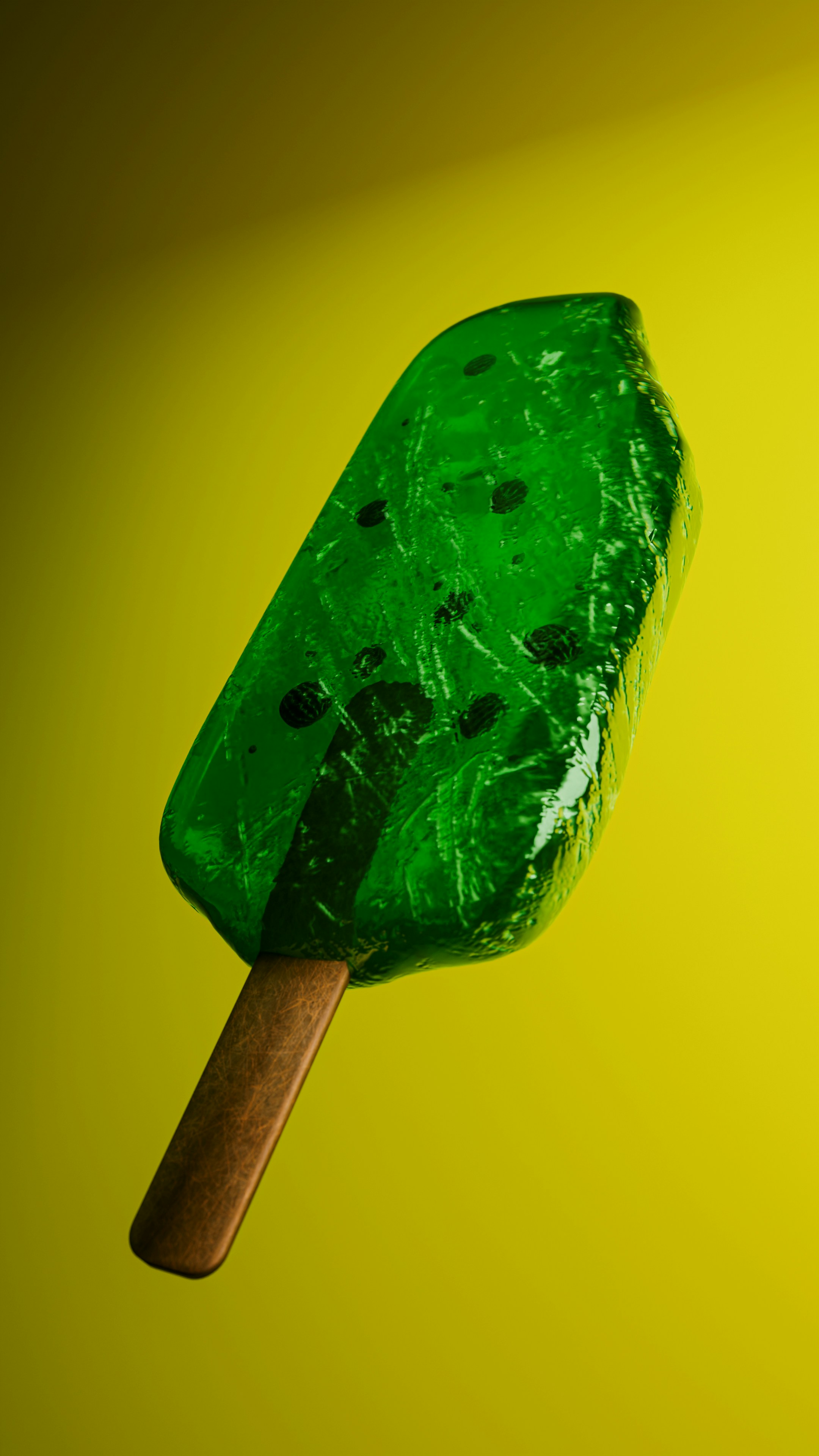 Green popsicle with dark specks on yellow background