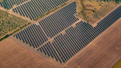 Aerial view of a large solar panel farm in a field