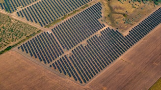 Aerial view of a large solar panel farm in a field