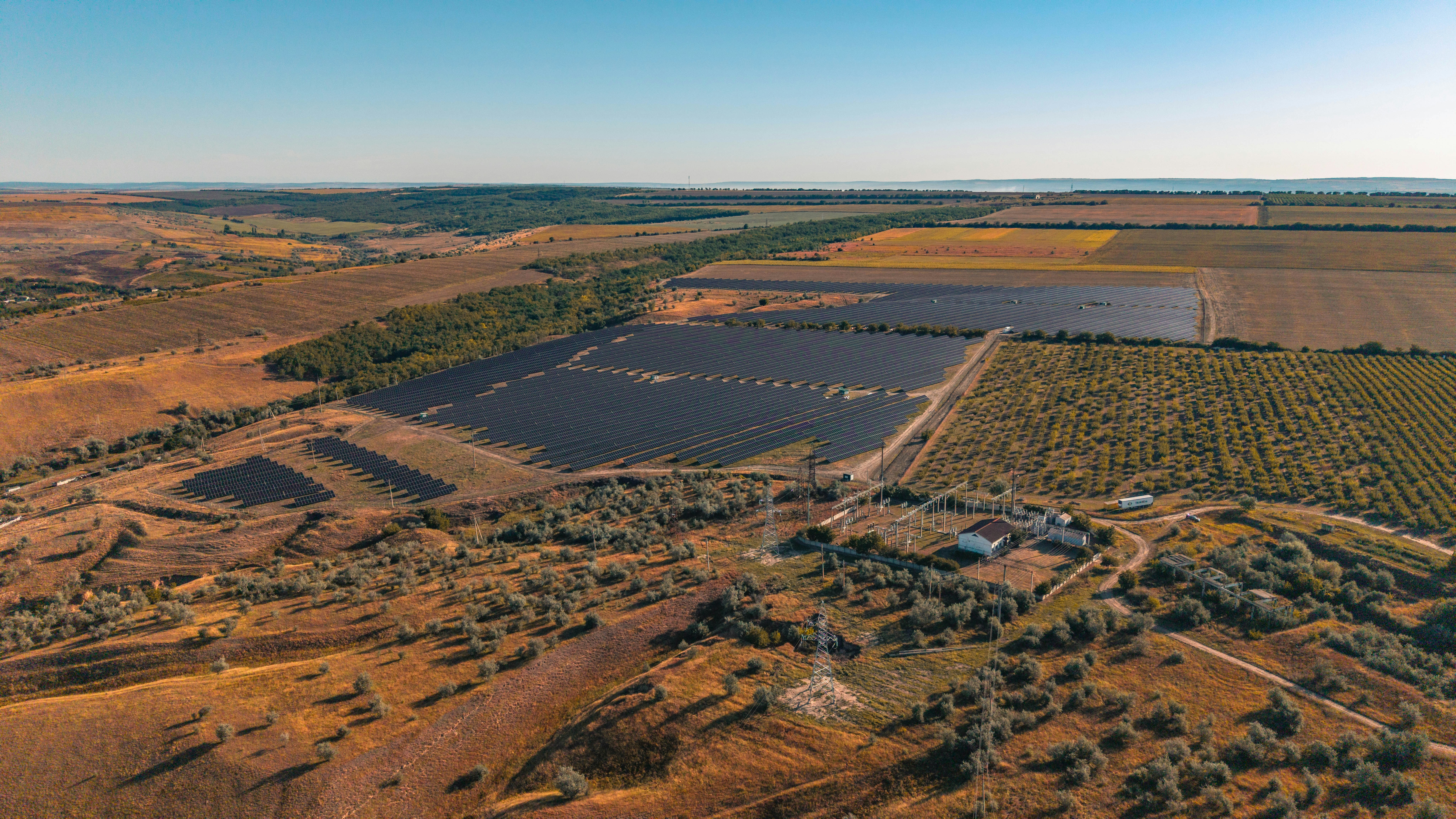 Aerial view of a large solar panel farm in a rural landscape.