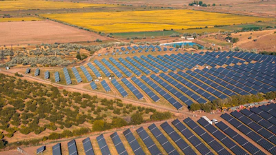 Aerial view of a large solar panel farm in a rural landscape.