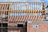 Building under construction with wooden roof trusses.
