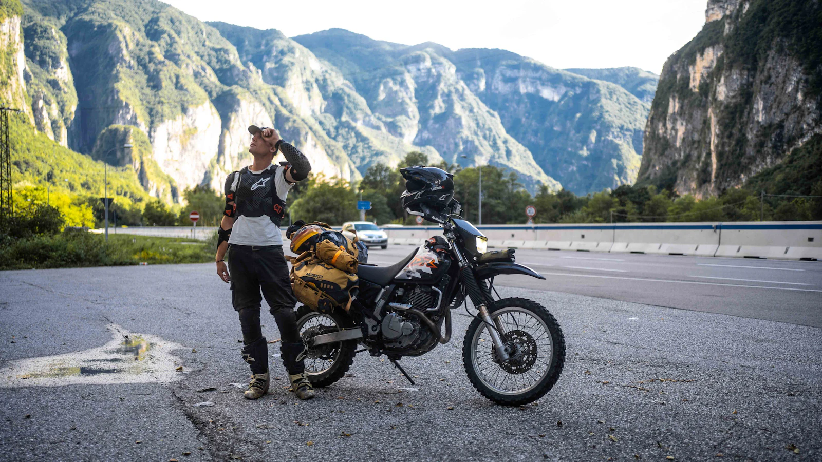 Motorista con su moto cargada en la montaña