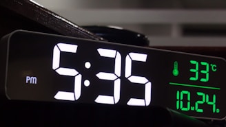 Digital clock displays 5:35 pm and 33 degrees celsius