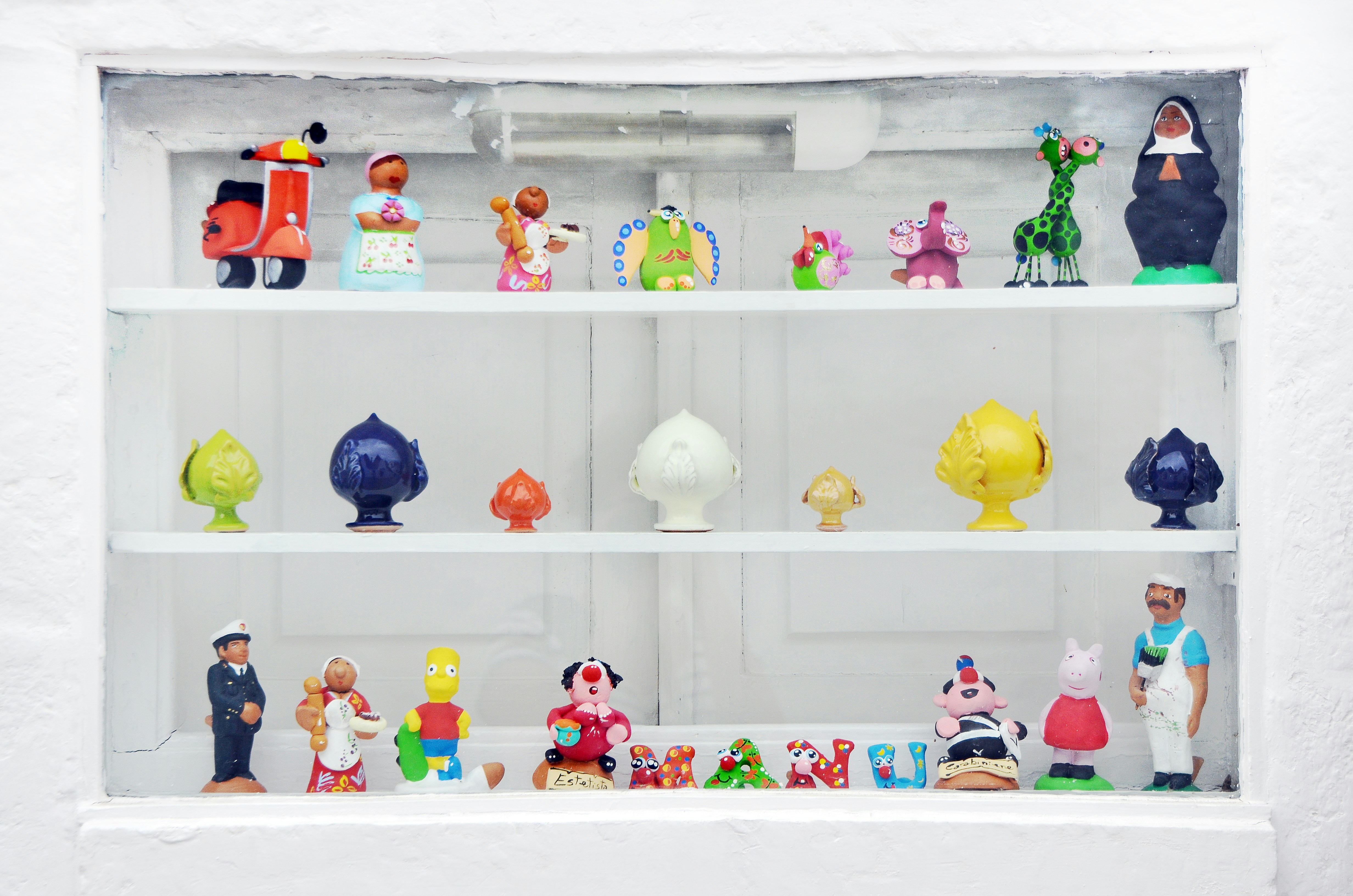 Collection of colorful figurines displayed on shelves