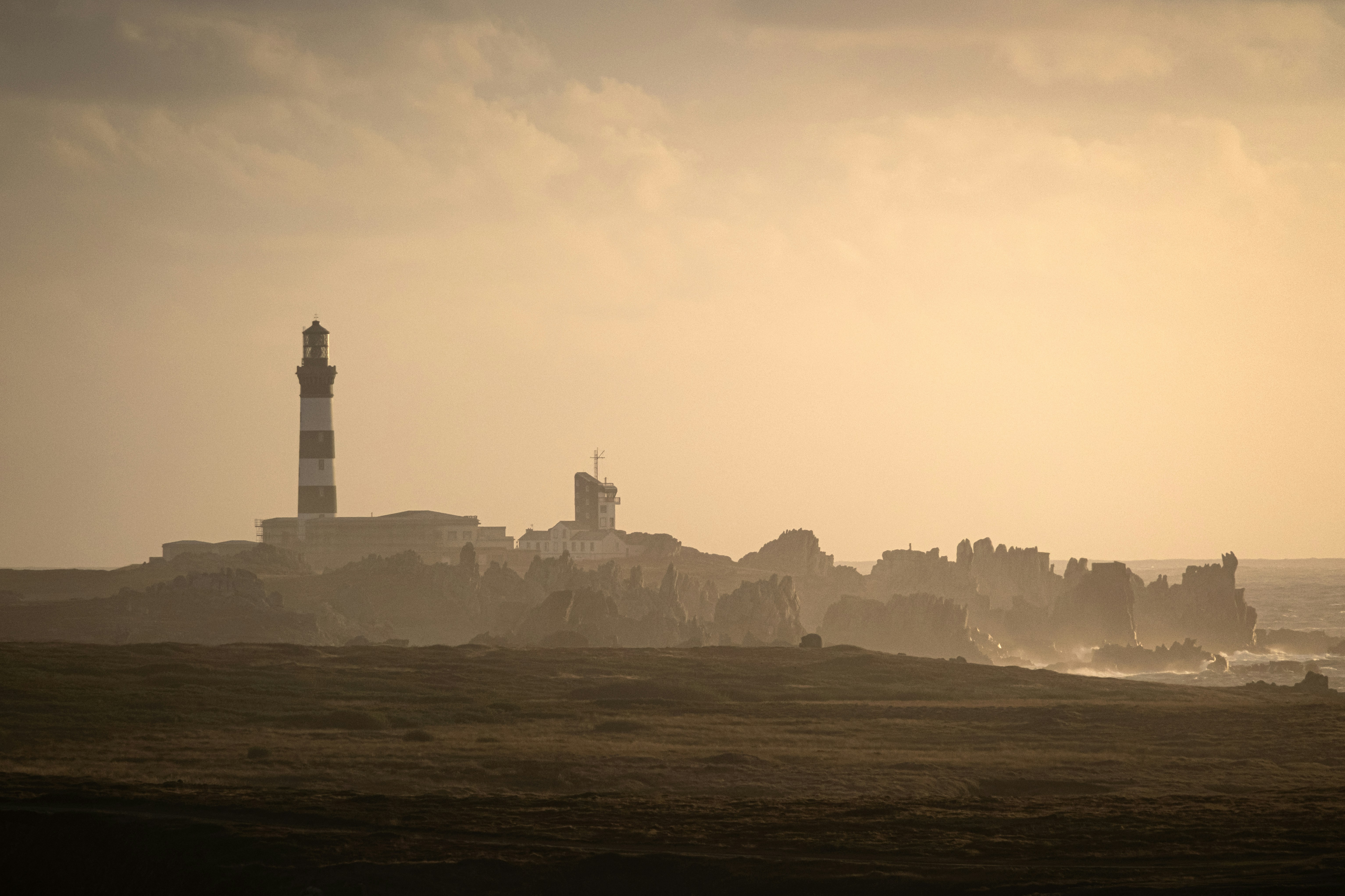 Faro su una costa rocciosa al tramonto