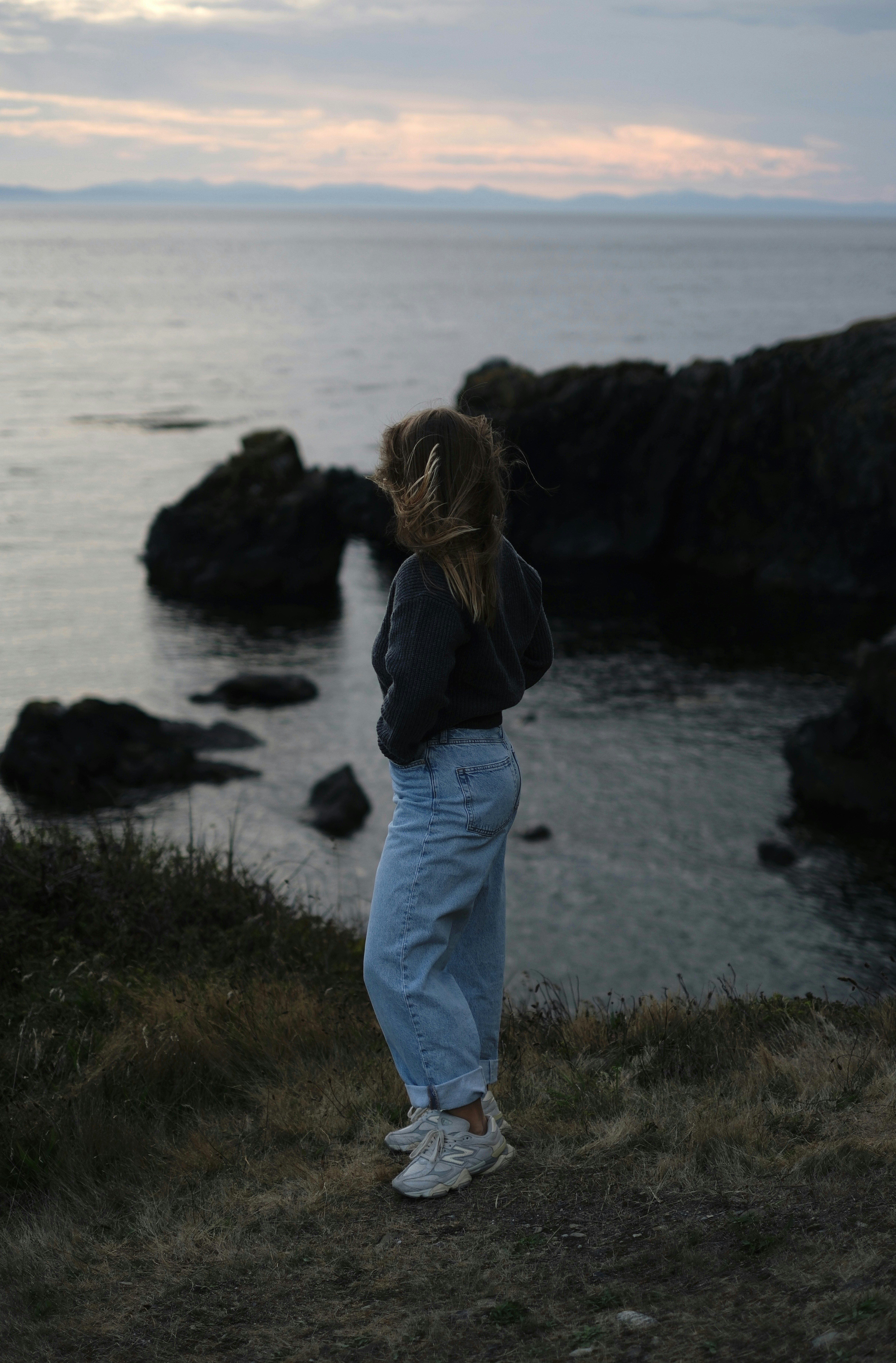 Woman looking at the ocean from a cliff