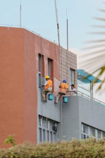 Workers painting the side of a building
