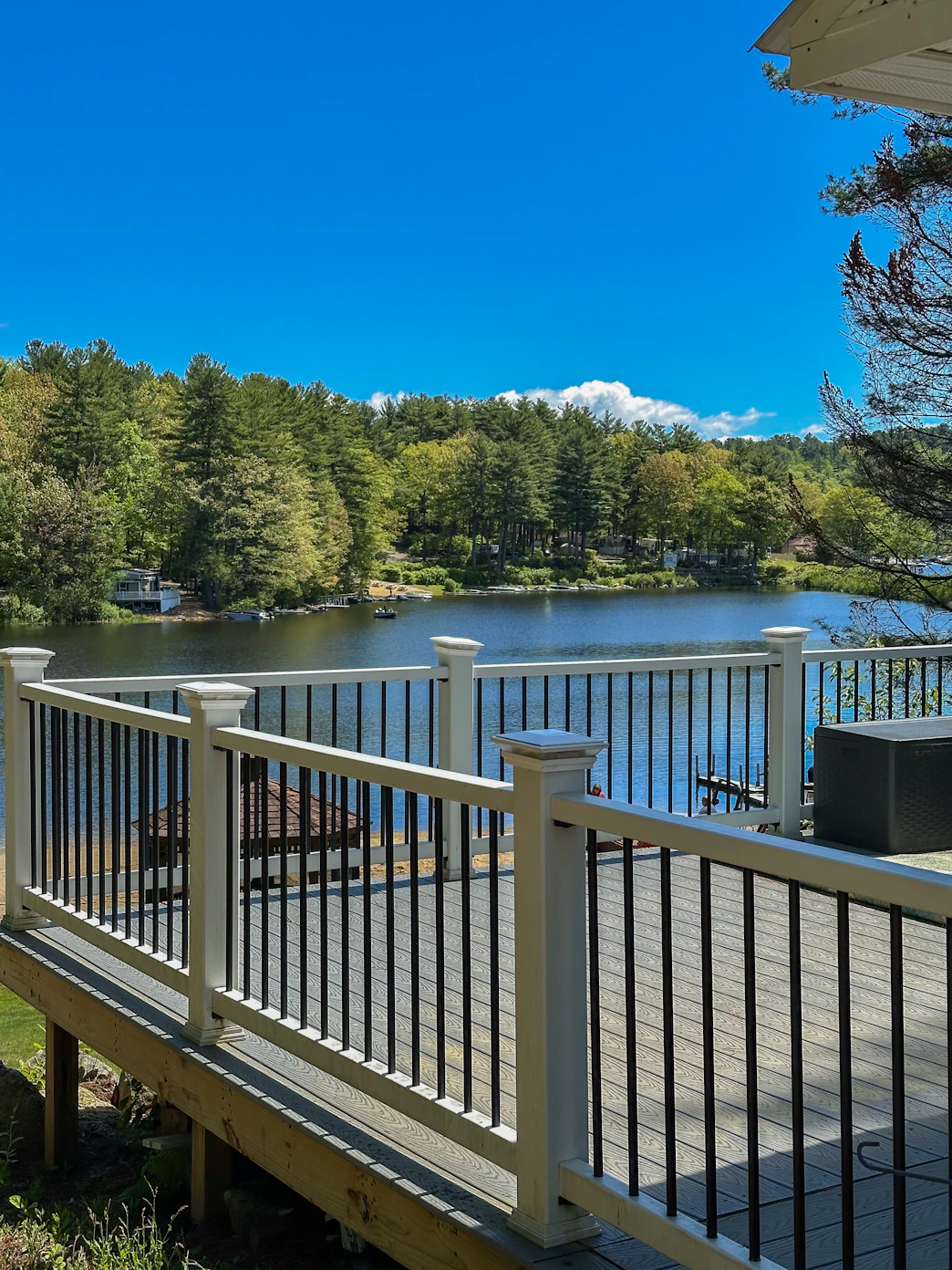 Deck overlooking a serene lake surrounded by trees