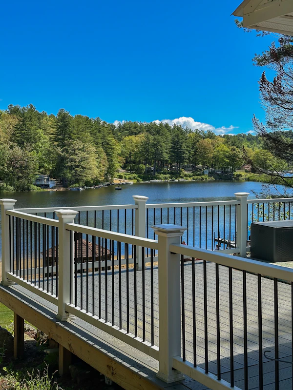 Deck overlooking a serene lake surrounded by trees