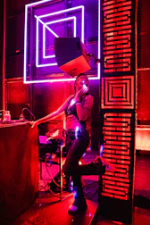 Woman posing under neon lights in a club.