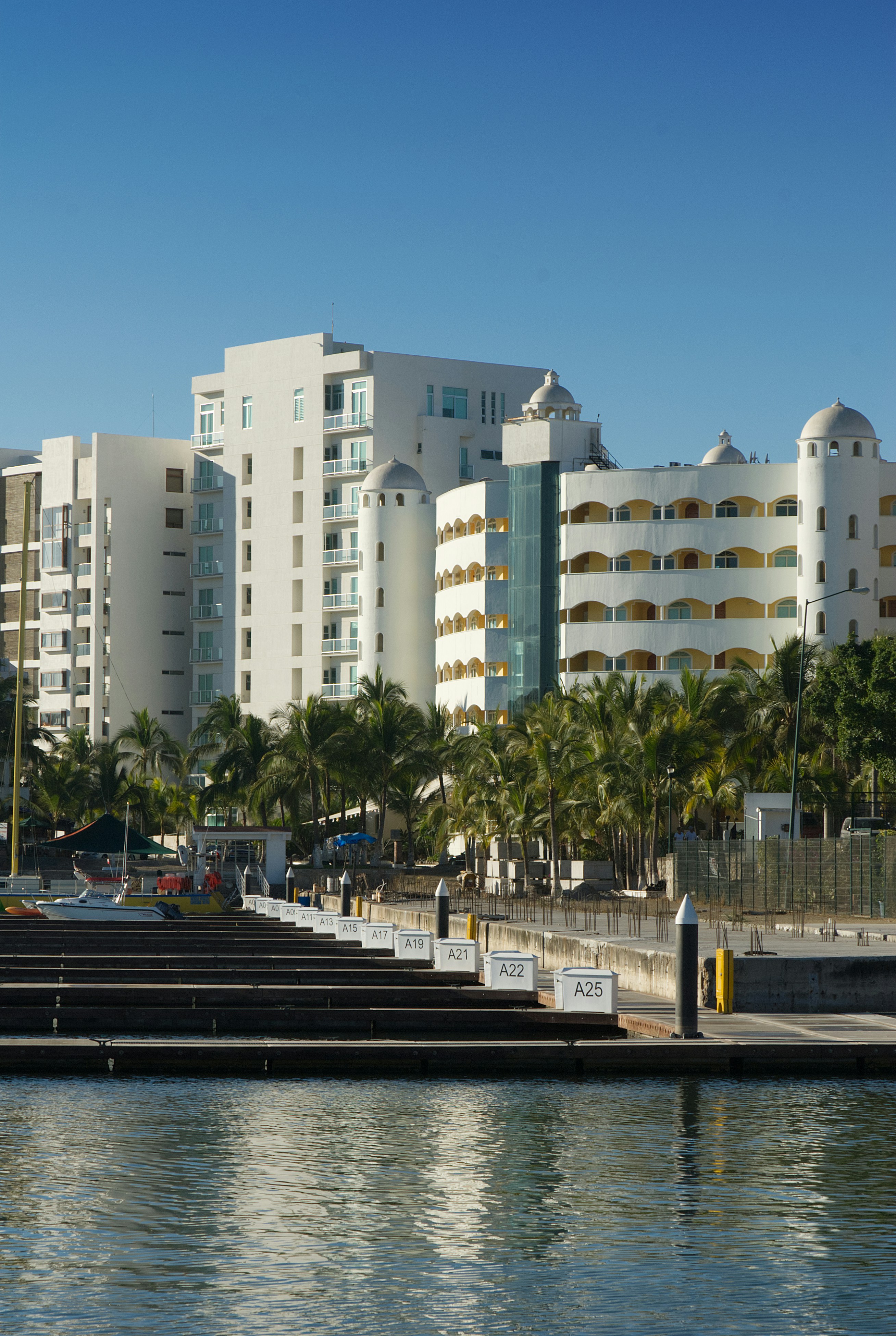 Bâtiments modernes de la station avec palmiers et port de plaisance
