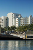 Modern resort buildings with palm trees and marina