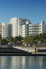 Modern resort buildings with palm trees and marina