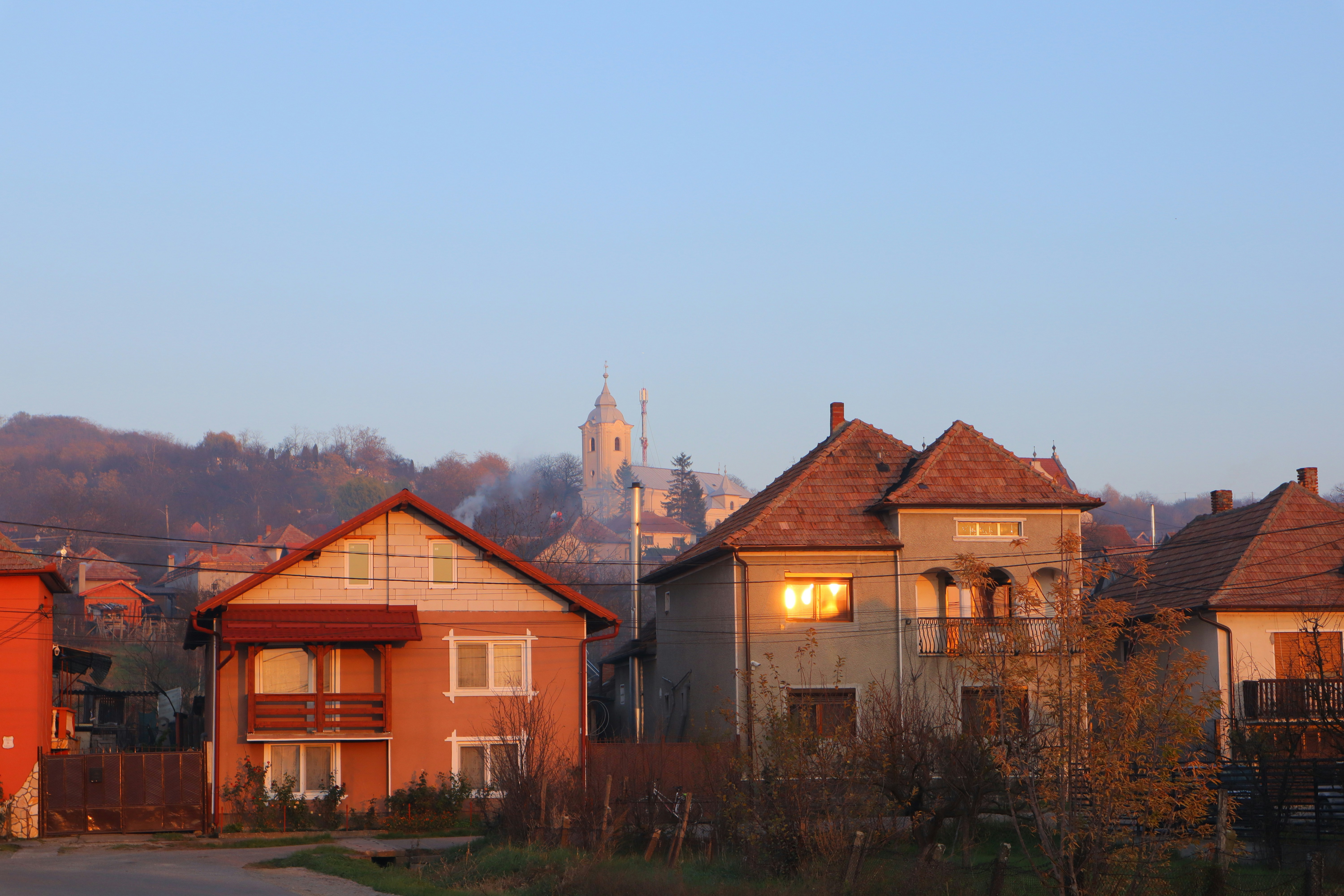 Houses and a church tower at sunrise