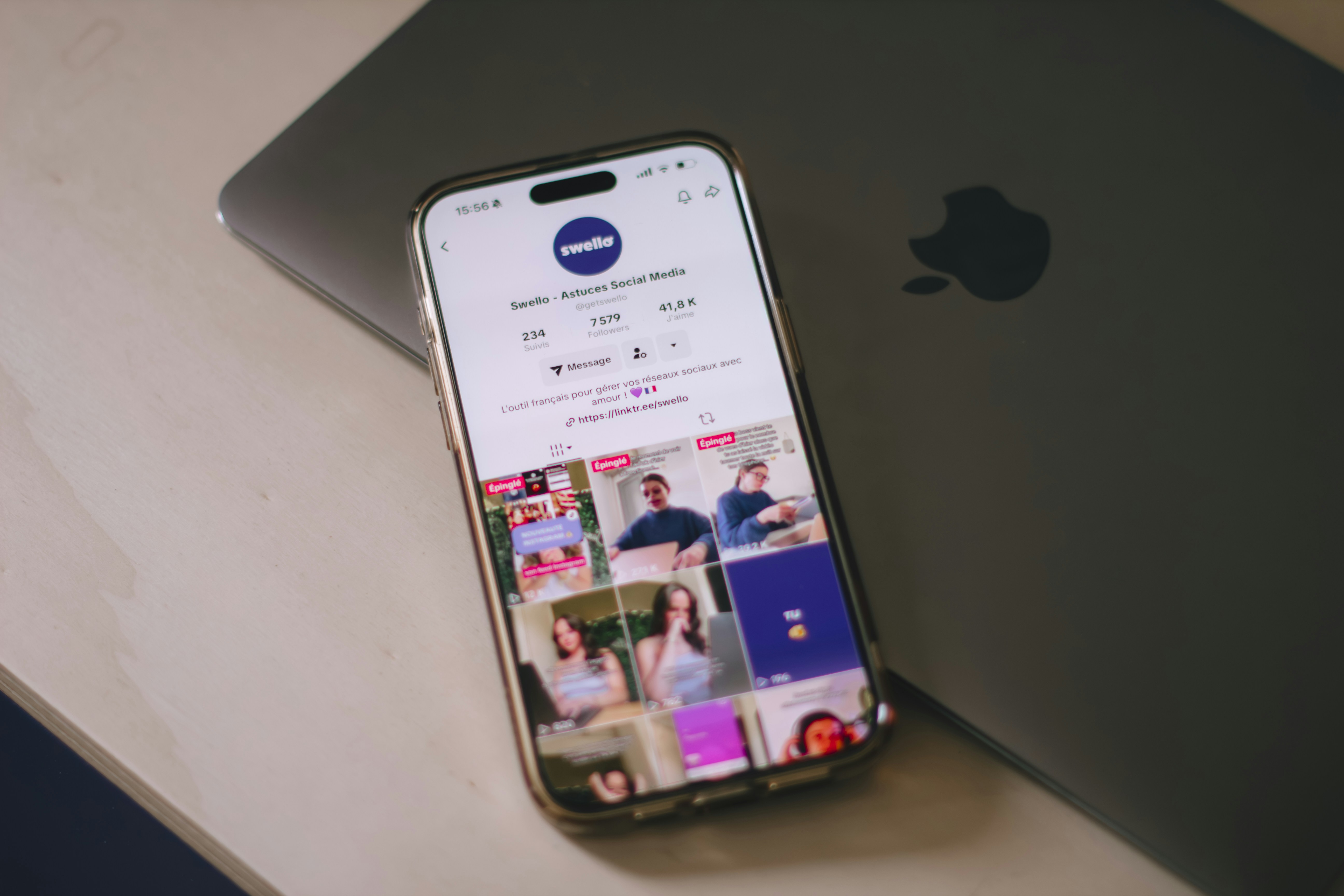 Teléfono inteligente que muestra las redes sociales junto a la computadora portátil