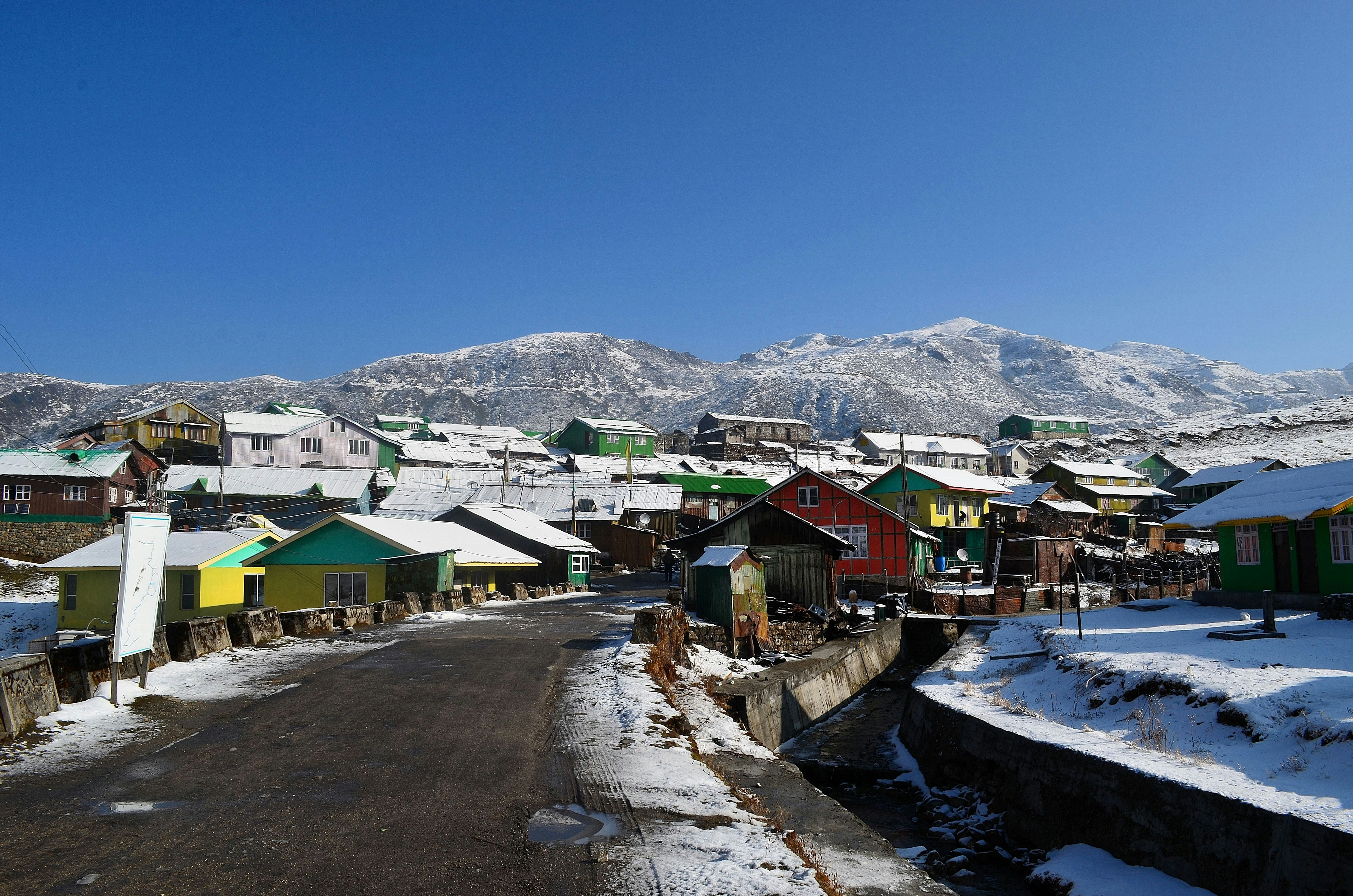 Colorful houses in a snowy village with mountains.