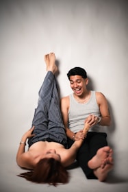 Couple playfully posing against a gray wall