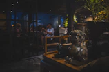 People dining in a dimly lit restaurant with decorative statues.