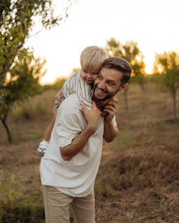 Father giving his son a piggyback ride outdoors