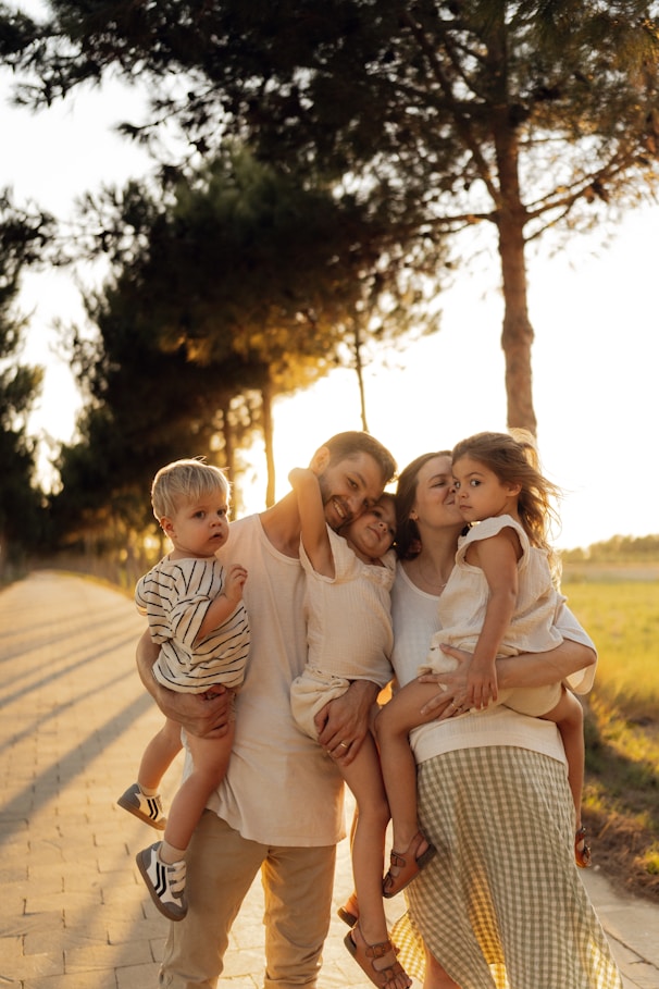 Family posing together outdoors during golden hour