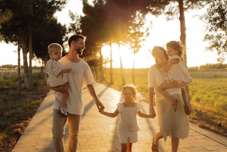 Family walking on path with trees at sunset