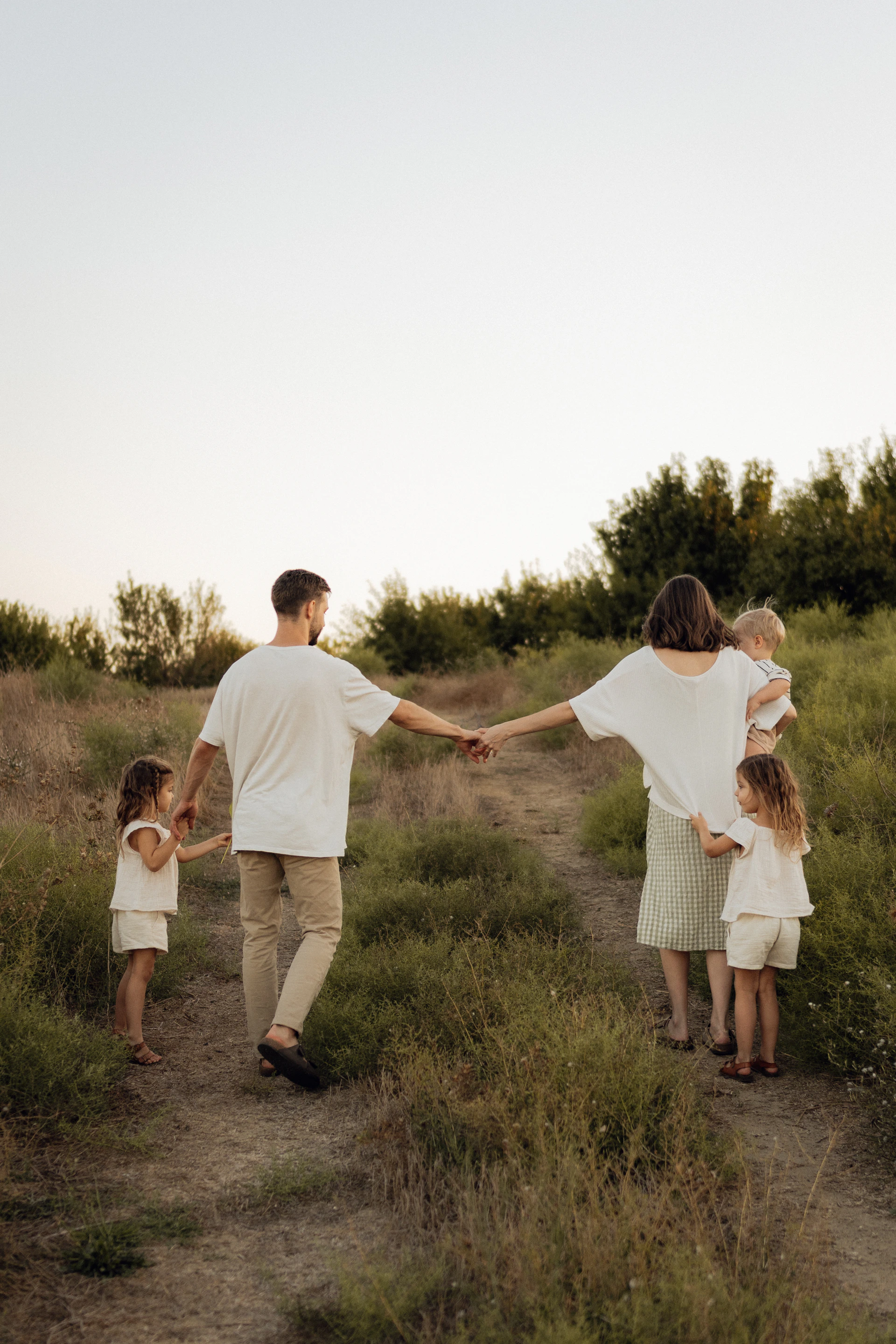 Family walking together on a grassy hill