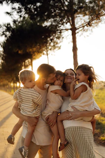 Family embracing during a golden hour sunset.