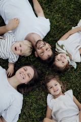 Family lying on grass with smiles