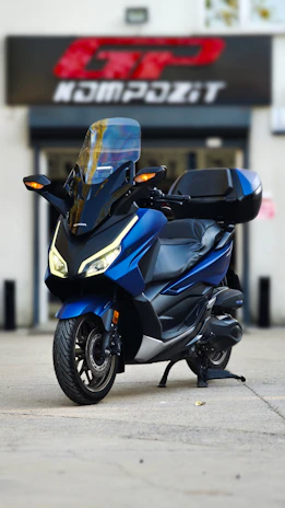 Blue scooter parked in front of a building