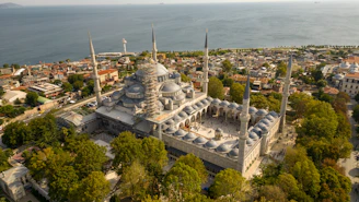Aerial view of a large, ornate mosque with minarets