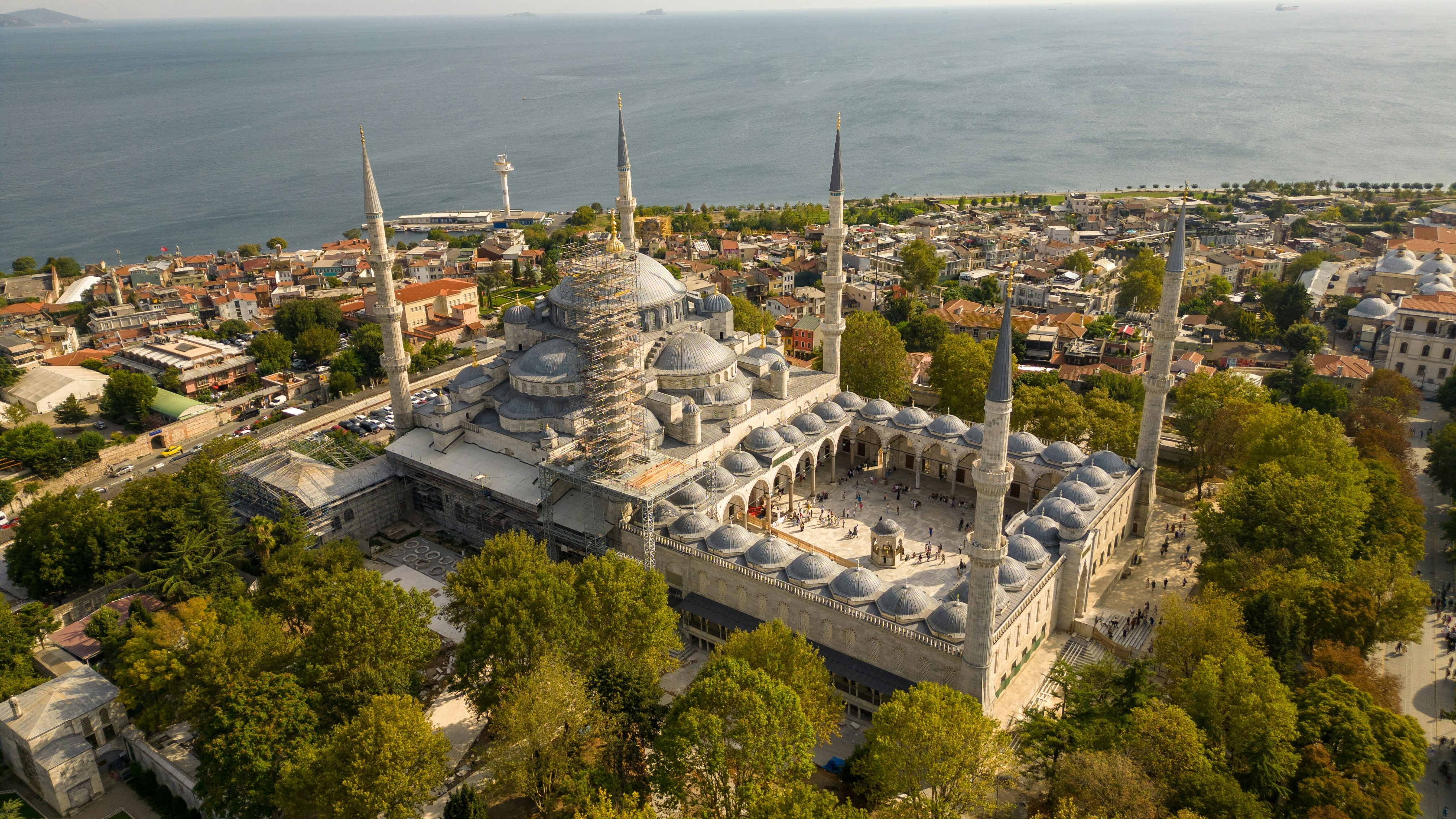 Aerial view of a large, ornate mosque with minarets.