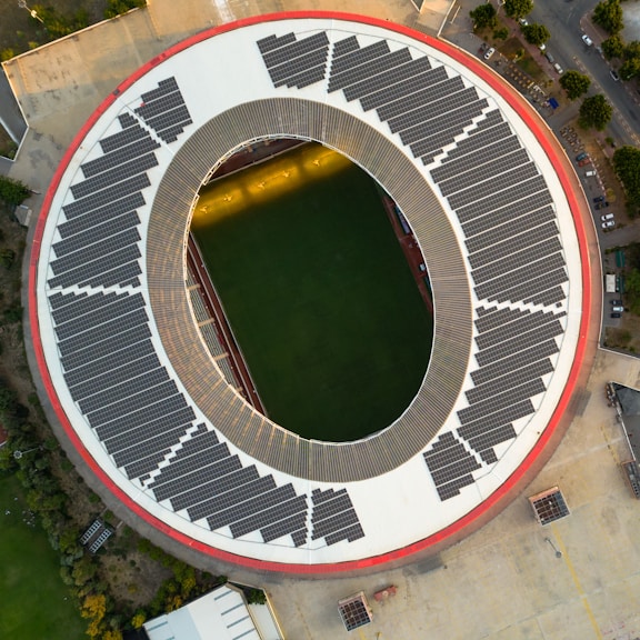 Aerial view of a stadium with solar panels on the roof.
