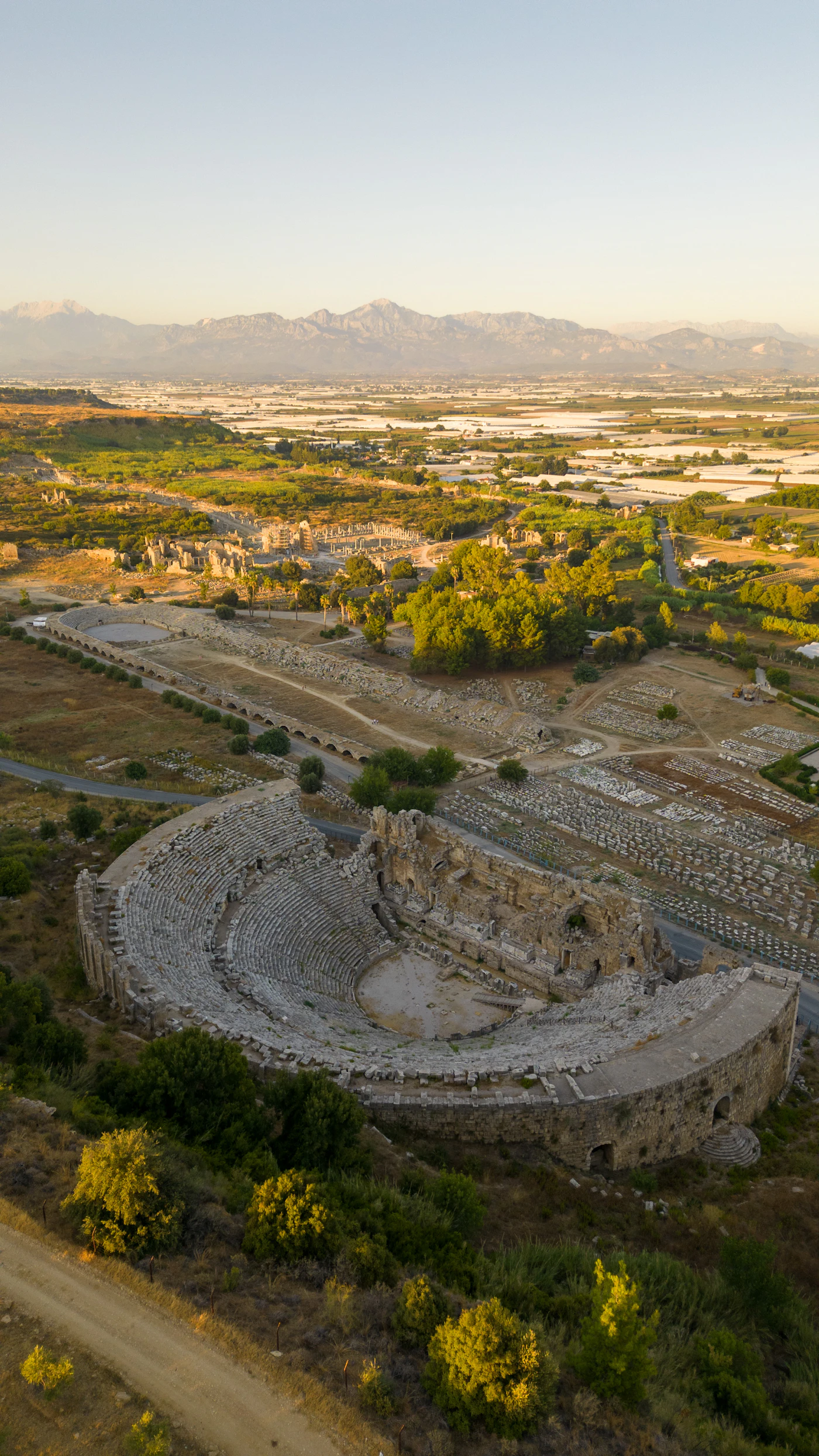 Ancient Roman amphitheater at sunrise with mountain backdrop
