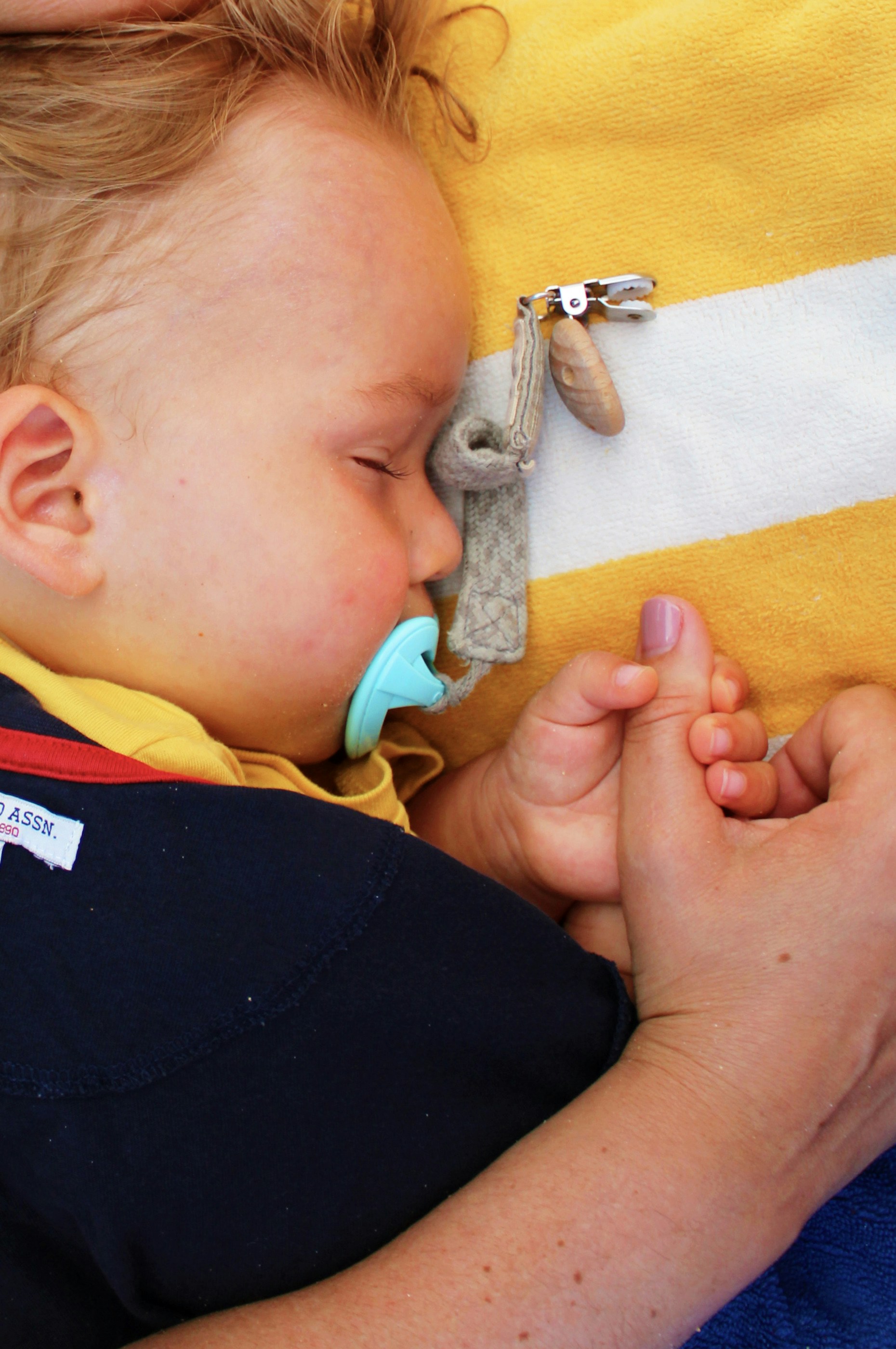 baby sleeping on yellow and white towel 
