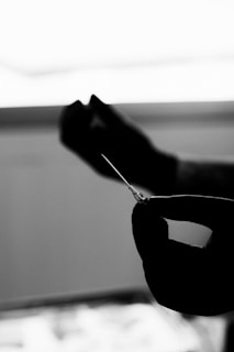 Close-up of a gloved hand holding a syringe